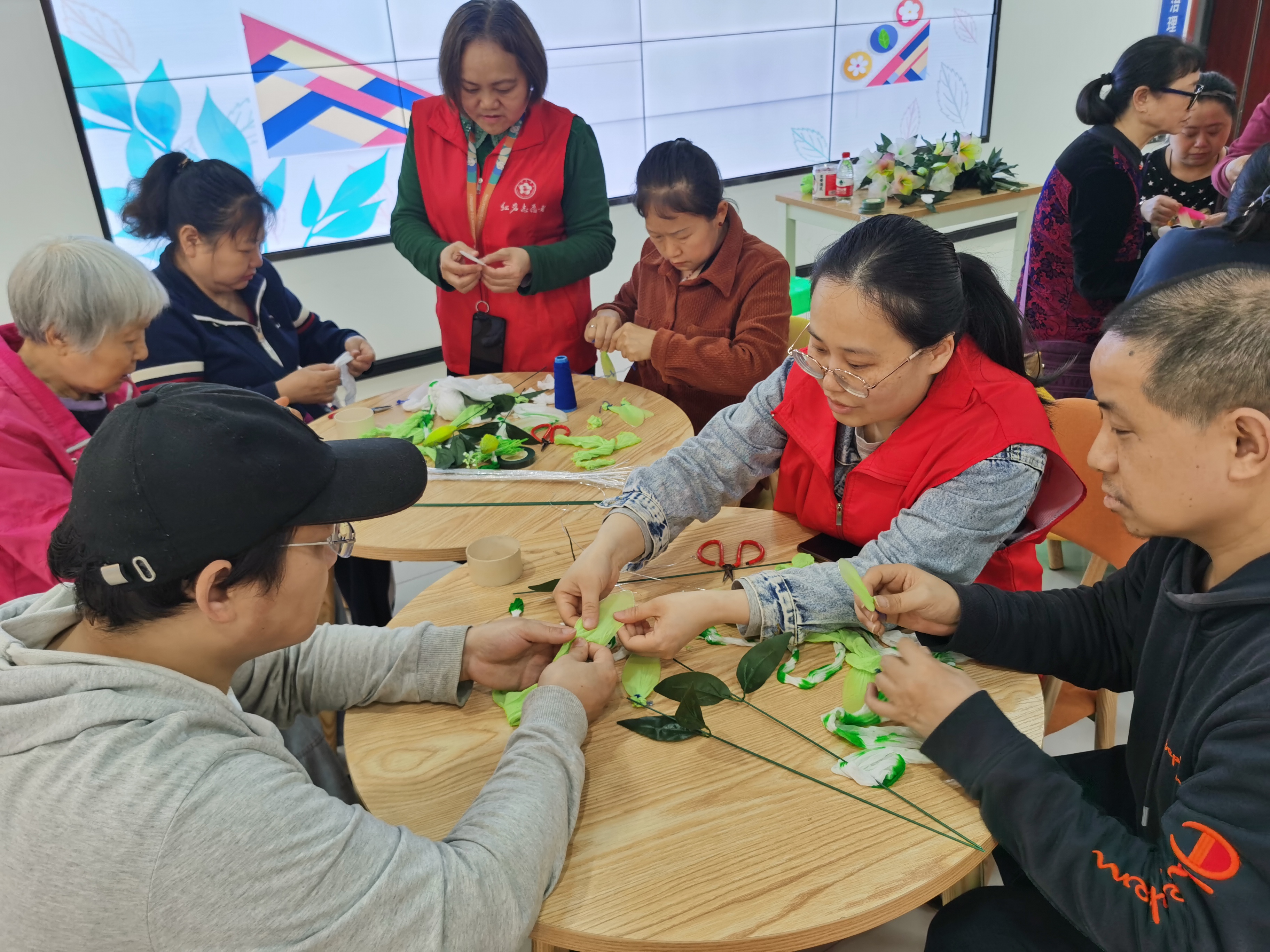 20250409-石井坡街道光荣坡社区残协“丝丝心动、巧手出花”多彩丝网花手工DIY助残活动图为志愿者与残疾人朋友一起作丝网花.jpg